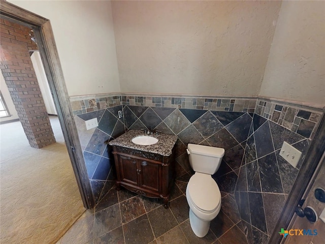 1260 Great Oaks Dr, Salado, TX 76571 - bathroom featuring tile walls, vanity, a wainscoted wall, and a textured wall