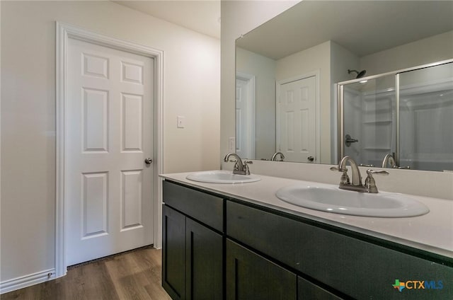 1003 Antelope Trl, Temple, TX 76504 - full bathroom featuring double vanity, wood finished floors, a shower with door, and a sink