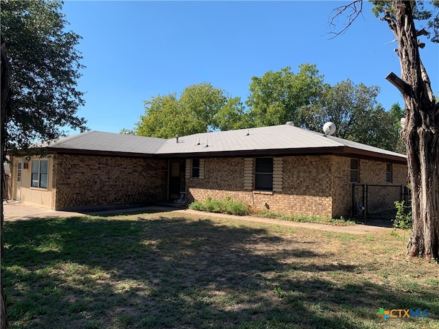 rear view of house featuring a yard