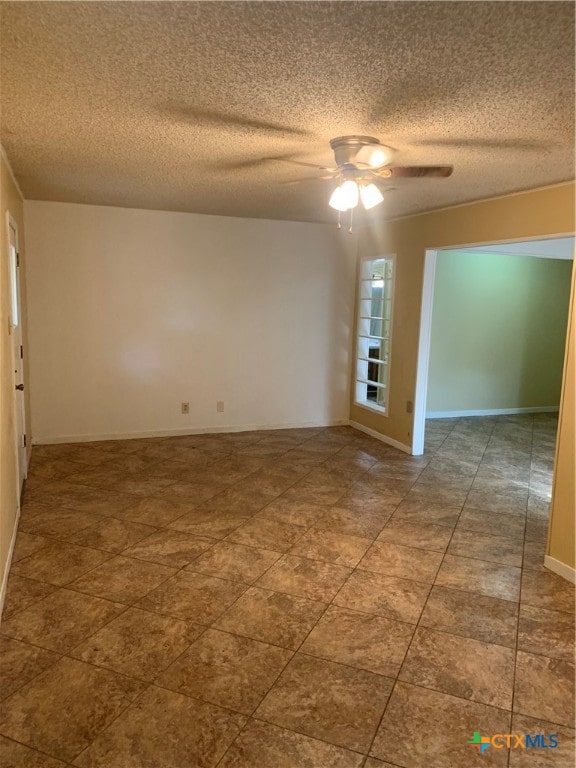 spare room with a textured ceiling and ceiling fan