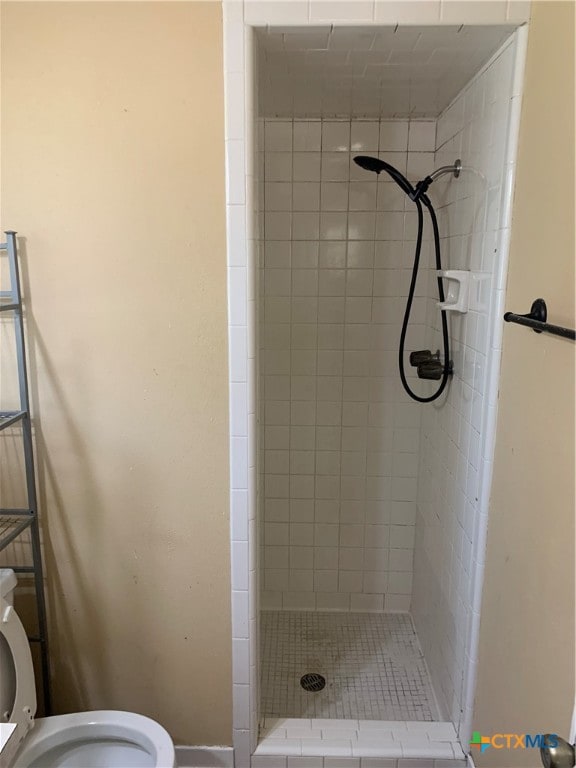 bathroom with toilet and tiled shower