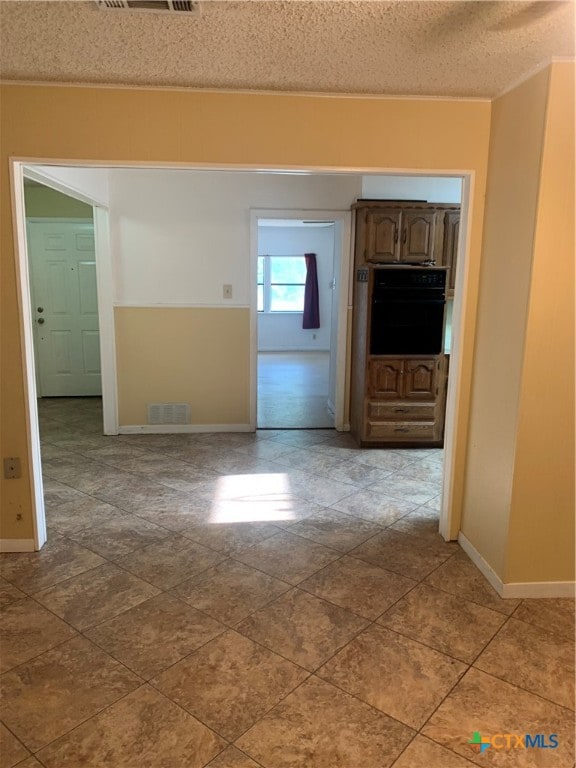 unfurnished room featuring a textured ceiling