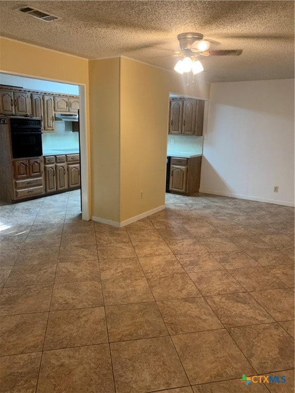 unfurnished room featuring ceiling fan and a textured ceiling