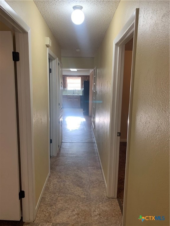 hallway with a textured ceiling