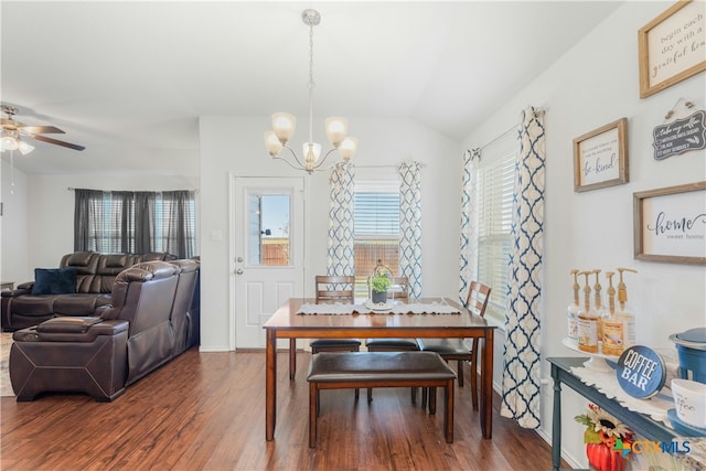 dining space featuring ceiling fan with notable chandelier, wood-type flooring, and vaulted ceiling