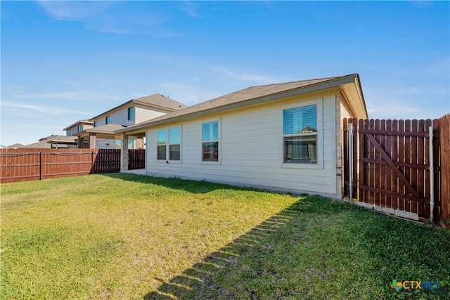 rear view of house featuring a yard