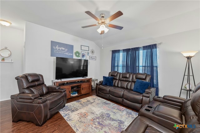 living room with ceiling fan, dark wood-type flooring, and vaulted ceiling