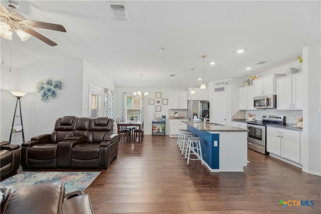 living room with ceiling fan with notable chandelier, sink, dark wood-type flooring, and vaulted ceiling