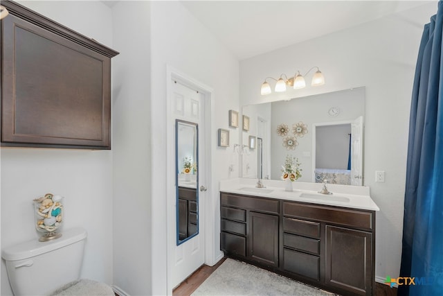 bathroom with hardwood / wood-style floors, vanity, and toilet