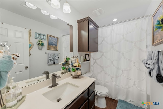 bathroom with hardwood / wood-style floors, vanity, and toilet