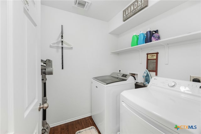 laundry room featuring washer and clothes dryer and dark wood-type flooring