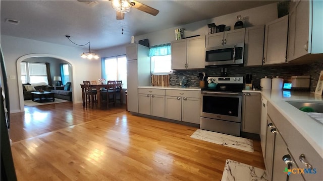 1804 N Goldman St, Victoria, TX 77901 - kitchen with stainless steel appliances, ceiling fan, decorative backsplash, light countertops, and light wood-style flooring