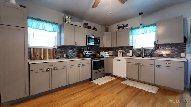 1804 N Goldman St, Victoria, TX 77901 - kitchen with appliances with stainless steel finishes, gray cabinets, decorative backsplash, and light wood-style flooring