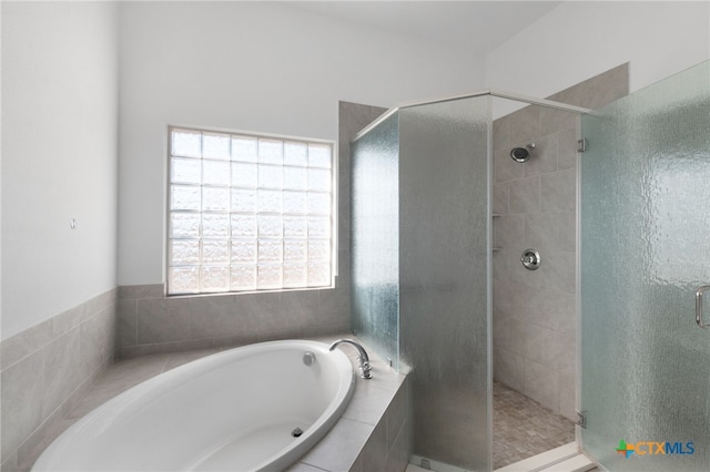 bathroom featuring independent shower and bath