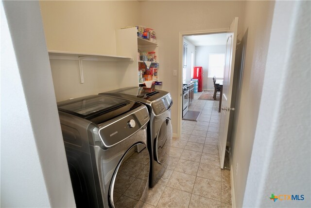 washroom with washing machine and clothes dryer and light tile patterned floors