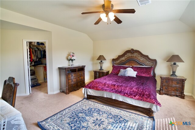 carpeted bedroom with ceiling fan, a spacious closet, vaulted ceiling, and a closet