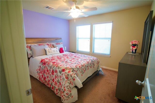 bedroom featuring ceiling fan and dark carpet