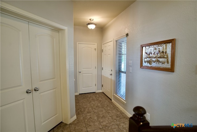 doorway to outside with light tile patterned flooring