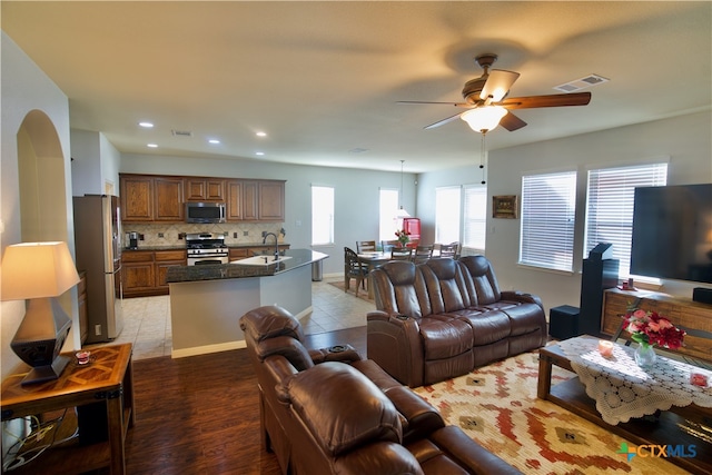 living room with sink, ceiling fan, and light hardwood / wood-style flooring