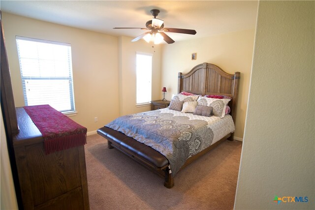 bedroom with ceiling fan, multiple windows, and carpet