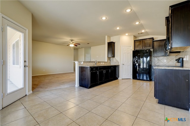 kitchen featuring decorative backsplash, light tile patterned floors, black fridge with ice dispenser, ceiling fan, and light stone countertops