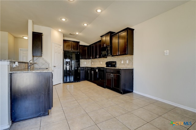 kitchen with lofted ceiling, dark brown cabinetry, black appliances, light tile patterned floors, and light stone countertops