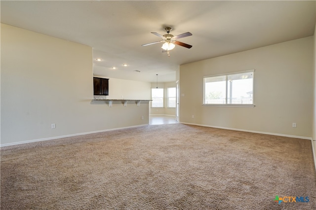 unfurnished living room featuring ceiling fan and carpet floors