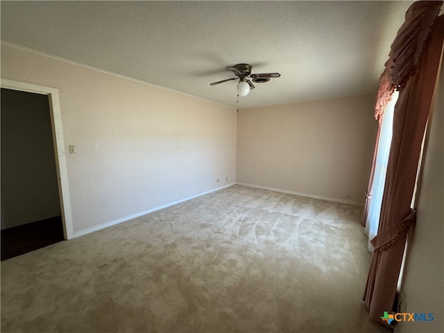 carpeted spare room featuring ceiling fan and a textured ceiling