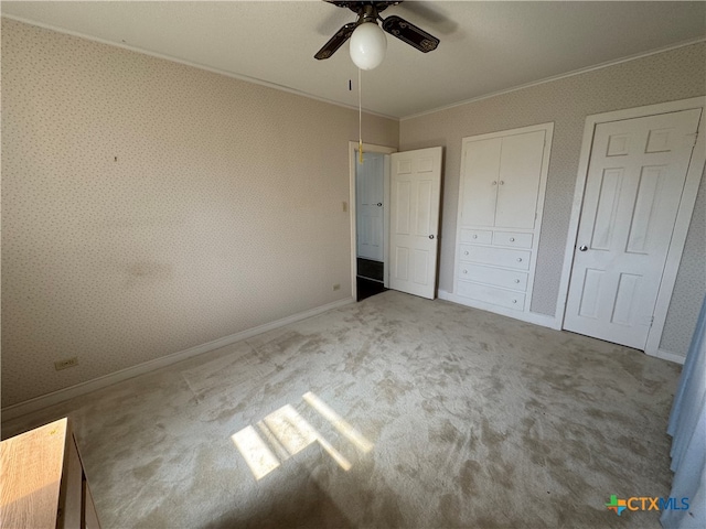 unfurnished bedroom with carpet, ceiling fan, and crown molding