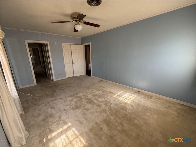 unfurnished bedroom featuring carpet, ceiling fan, crown molding, and a textured ceiling