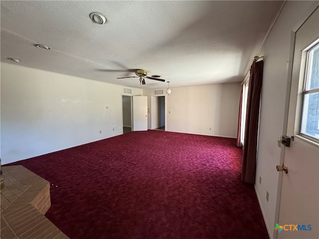 empty room with carpet, ceiling fan, and a textured ceiling