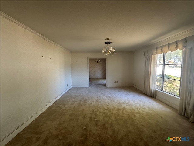 carpeted spare room with ornamental molding and an inviting chandelier