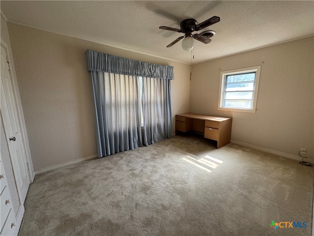 unfurnished bedroom featuring ceiling fan, light colored carpet, and a textured ceiling