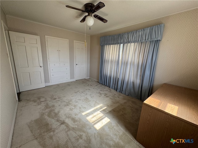 unfurnished bedroom with light colored carpet, ceiling fan, and crown molding