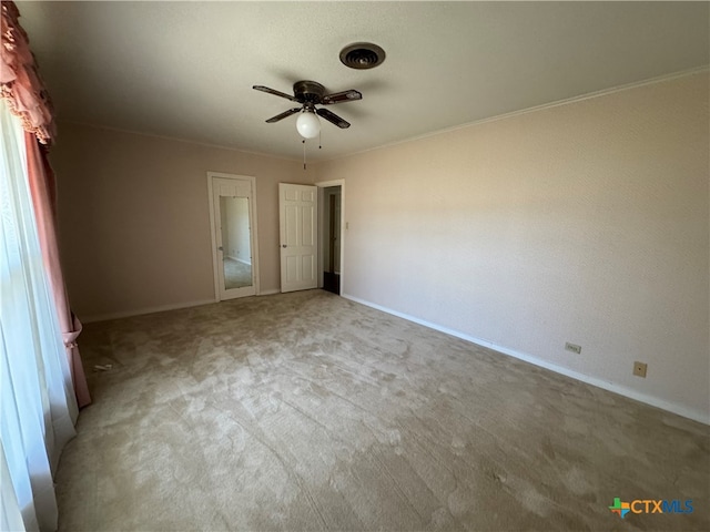 unfurnished bedroom featuring ceiling fan, crown molding, and light carpet