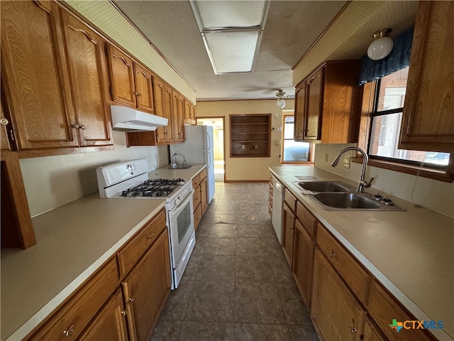 kitchen with a textured ceiling, ceiling fan, sink, and white appliances