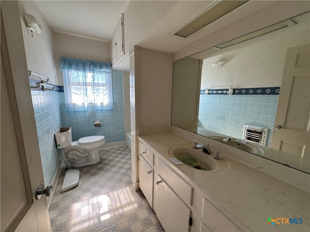 bathroom featuring vanity, toilet, and tile walls