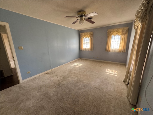 carpeted empty room with ceiling fan and a textured ceiling