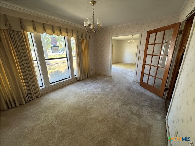 unfurnished room featuring carpet, ornamental molding, a textured ceiling, and a notable chandelier