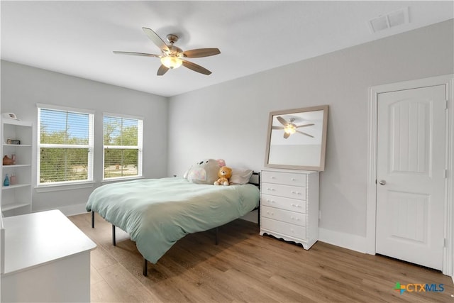 bedroom featuring visible vents, ceiling fan, baseboards, and light wood-style floors