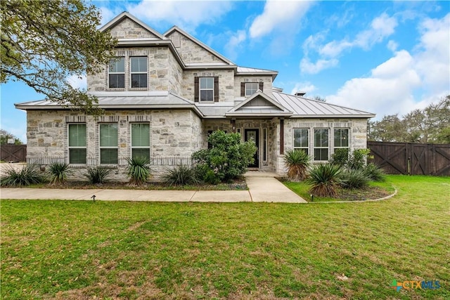 view of front of home with a standing seam roof, metal roof, a gate, fence, and a front lawn