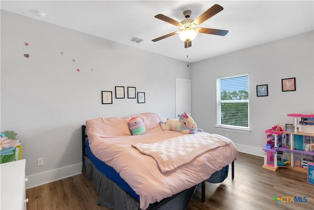 bedroom featuring wood finished floors, visible vents, a ceiling fan, and baseboards