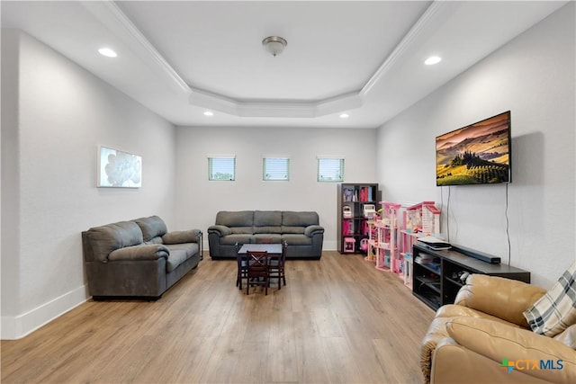 living room featuring recessed lighting, baseboards, wood finished floors, and a tray ceiling