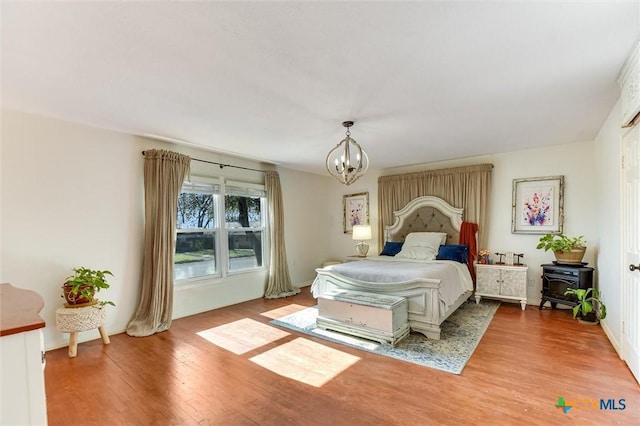 bedroom with a notable chandelier and wood finished floors