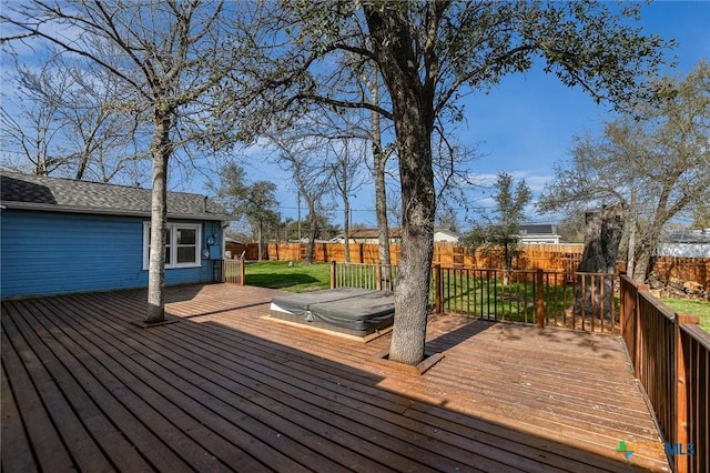 wooden terrace with a covered hot tub and a fenced backyard