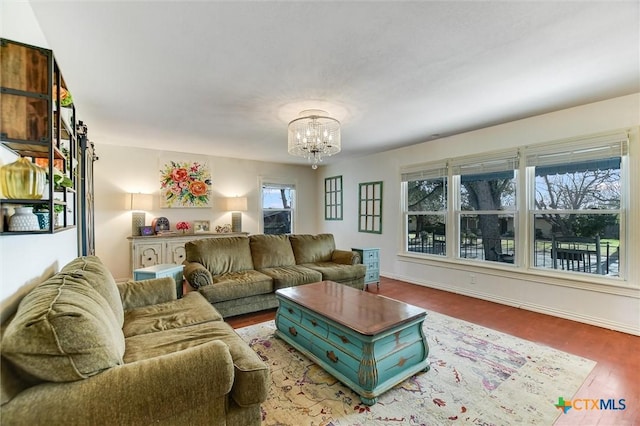 living room featuring baseboards, an inviting chandelier, and wood finished floors