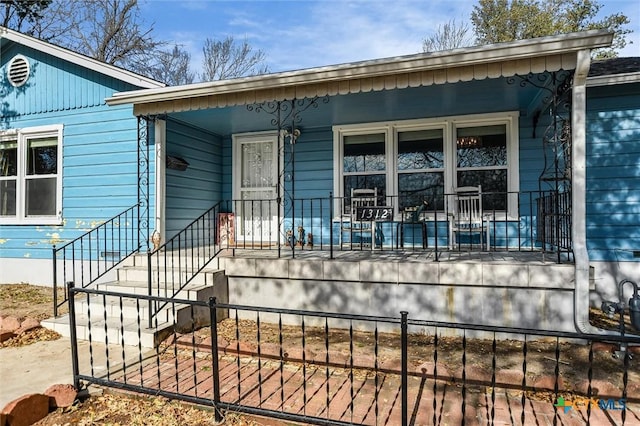 view of front of property featuring a porch and a fenced front yard