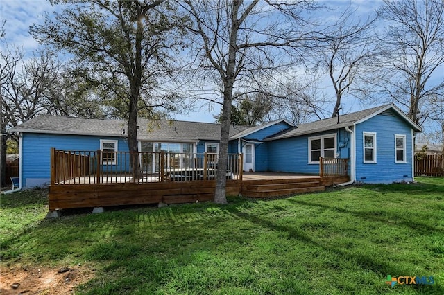 rear view of property with a yard, fence, and a wooden deck