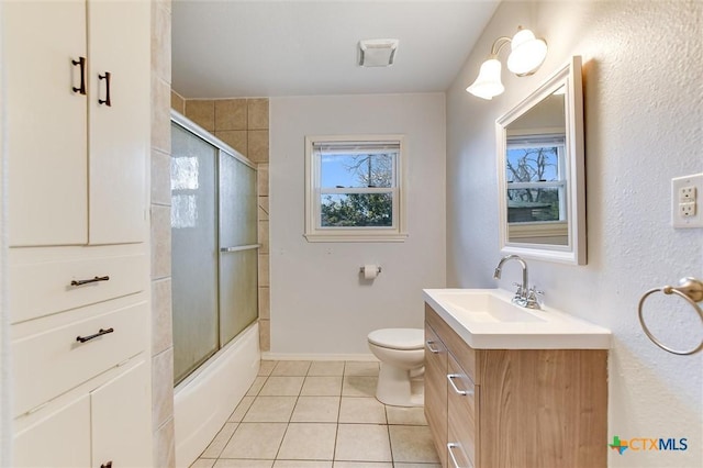 bathroom with tile patterned flooring, baseboards, bath / shower combo with glass door, toilet, and vanity