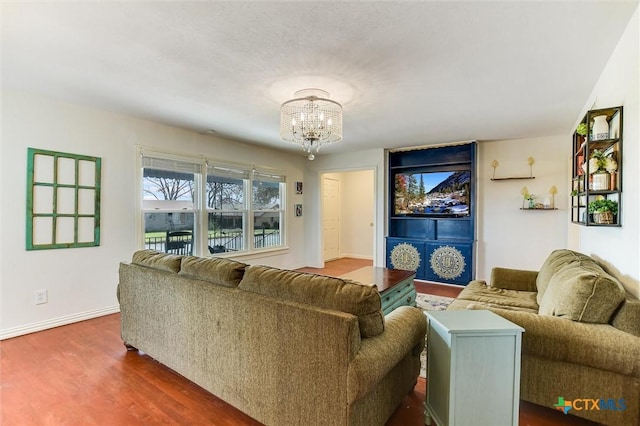 living room with a notable chandelier, dark wood-type flooring, and baseboards